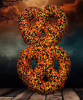 Festive Halloween chocolate-covered pretzels with orange, black, and yellow sprinkles against a spooky night sky background.