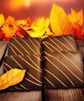 Fall-themed chocolate squares with an orange drizzle, surrounded by autumn leaves on a wooden table background.