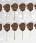 Set of 12 handcrafted milk chocolate Santa lollipops with festive red bows, perfect for Christmas stocking stuffers.