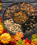 Thanksgiving nut tray with gourmet sweet and salty snacks, including chocolate turkey lollipops, surrounded by festive fall decor.