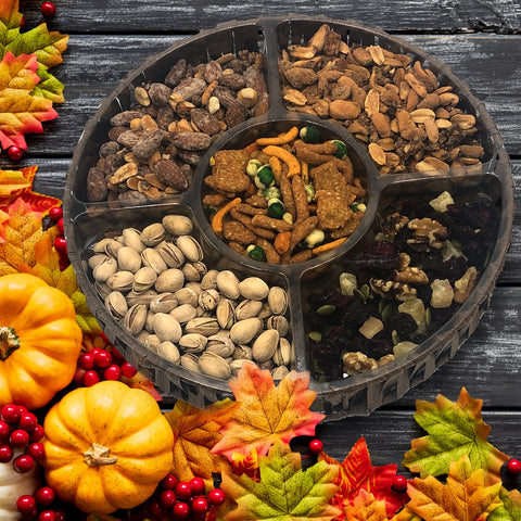 Thanksgiving nut tray with gourmet sweet and salty snacks, including chocolate turkey lollipops, surrounded by festive fall decor.