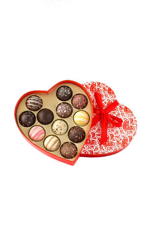 Heart-shaped box of 12 gourmet truffles with assorted chocolate flavors, perfect for Valentine's Day gift.