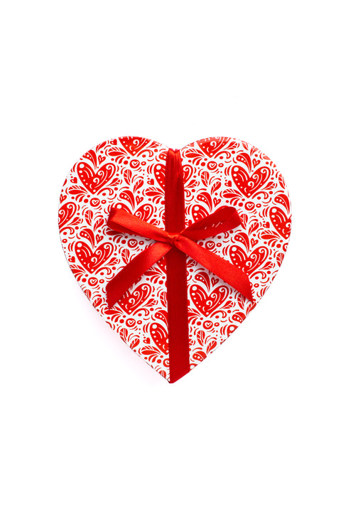 Heart-shaped gift box with red ribbon, perfect for Valentine's Day chocolates or truffles.