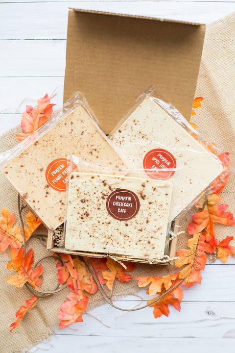 Pumpkin Bark Variety Box with Pumpkin Spice, Cheesecake, and Peanut Butter flavors on a fall-themed background.